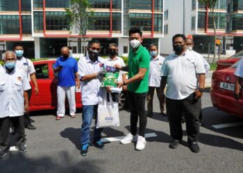 KETUA Pemuda Negara Negeri Johor, Saiful Bahari (tiga dari kanan) menyerahkan bantuan kepada Mohd. Zamri Mahazan yang mewakili pemandu teksi bandar di Larkin Sentral di Johor Bahru, Johor. - UTUSAN/RAJA JAAFAR ALI