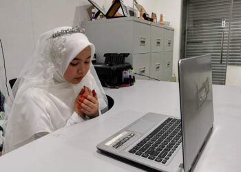 FATIN Farhanah Solahuddin mengaminkan doa selepas selesai majlis pernikahannya dengan pasangan yang diikuti secara dalam talian kerana menjalani kuarantin hari ketiga di Kampung Kepah, Hulu Terengganu.