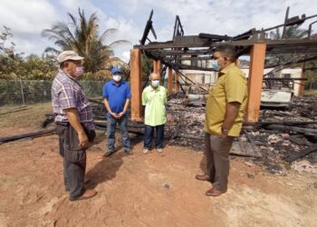 MUHAMMAD Amin Abdul Ghani (dua dari kanan) yang kehilangan rumah akibat kebakaran menerima kunjungan K. Raven Kumar (kanan) dan Mohd. Youzaimi Yusof (dua dari kiri) di Kampung Pengkalan Batu, Mersing, Johor. - UTUSAN/MASTURAH SURADI