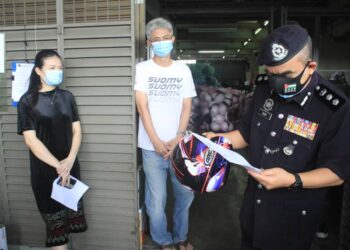 NOORZAINY Mohd. Noor memeriksa surat kebenaran beroperasi dari pemilik sebuah kilang yang menghasilkan topi keledar dalam operasi bersepadu beberapa agensi di Butterworth, Pulau Pinang.