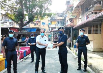 JAGDEEP Singh Deo (kiri) menyerahxkan pelitup muka kepada Ketua Polis Daerah Timur Laut, Asisten Komisioner Sofian Santong ketika menjalankan tinjauan di Pasar Awam Taman Free School, Georgetown, Pulau Pinang.