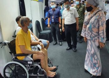 CHOW Kon Yeow dan Dr. Jemilah Mahmood  bertanyakan sesuatu kepada warga emas yang menerima suntikan vaksin Covid-19 pada hari pertama operasi PPV Spice Arena, Bayan Baru, Pulau Pinang.