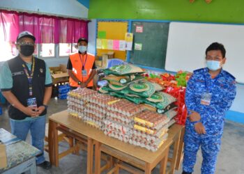 KOMANDAN PKPD Simpang Juasseh, Ahmad Syafiq Amin (kiri) menunjukkan bekalan makanan kering yang mencukupi bagi semua penduduk yang terlibat dalam kawasan tersebut.- UTUSAN/ZAKKINA WATI AHMAD TARMIZI.