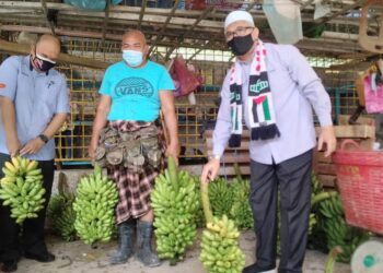 RAZMAN Zakaria (kanan) ketika bertemu pemborong hasil pertanian berikutan kesukaran memasarkan hasil pertanian disebabkan PKP di Batu Kurau, semalam. - UTUSAN/WAT KAMAL ABAS