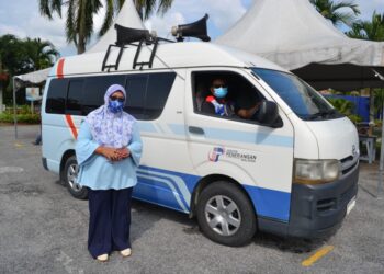 PEMBANTU Penerangan, Hasrulazlinda Hassan (kiri) bersama rakan setugas menjalankan hebahan awam mengenai SOP kepada penduduk yang dikenakan Perintah Kawalan Pergerakan Diperketatkan (PKPD) Simpang Juasseh. UTUSAN/ZAKKINA WATI AHMAD TARMIZI