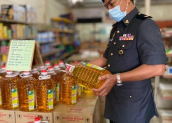 SEORANG Penguatkuasa  Kementerian Perdagangan Dalam Negeri Hal Ehwal Pengguna (KPDNHEP) Pahang melakukan pemeriksaan harga minyak masak di sebuah kedai runcit di Bandar Jerantut, Jerantut, Pahang. - UTUSAN/HARIS FADILAH AHMAD