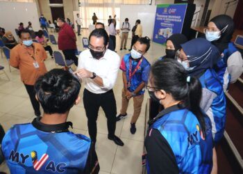 WAN Ahmad Fayhsal Wan Ahmad Kamal, beramah mesra dengan petugas MyVac ketika melawat Pusat Pemberian Vaksin di Dewan Majlis Bandaraya Seremban, Seremban hari ini.-FOTO/MOHD SHAHJEHAN MAAMIN.