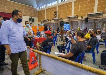 AHMAD Samsuri Mokhtar (kiri) menunjukkan isyarat bagus kepada seorang penerima vaksin di Pusat Pemberian Vaksin (PPV) Marang di Marang. - UTUSAN/FACEBOOK DR. AHMAD SAMSURI MOKHTAR