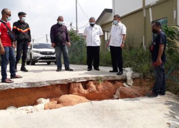 CHE Zakaria Mohd. Salleh (dua kanan) melihat kawasan tanah runtuh yang berlaku di belakang kediaman penduduk Taman Scientex, Pasir Gudang di Johor. -UTUSAN/KHAIRUL MOHD ALI