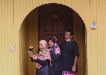 NURUL Yasmin Sofiya Roshaizad gembira melihat keputusan  Sijil Pelajaran Malaysia (SPM) 2020 bersama ibu bapanya di kediaman mereka di Kampung Kubang Machang, Kuala Terengganu hari ini. -UTUSAN/ PUQTRA HAIRRY ROSLI
