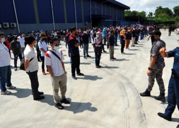 ANGGOTA penguat kuasa memeriksa 257 pekerja sebuah kilang alat ganti basikal yang didapati melanggar SOP PKP 3.0 di kawasan perindustrian Senai di Kulai, Johor. - UTUSAN/RAJA JAAFAR ALI