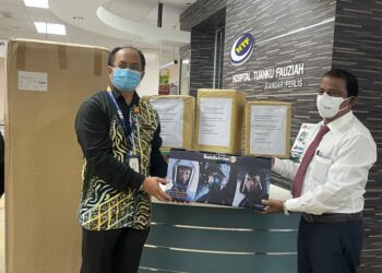 OTHMAN WARIJO (kiri) menerima sumbangan peralatan untuk kegunaan di wad Covid-19 daripada Dr. C.Muthuveerappan di lobi HTF, Kangar, Perlis. - UTUSAN/NAZLINA NADZARI