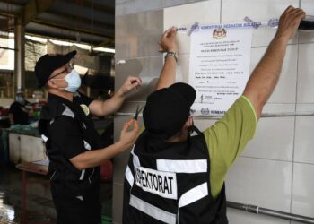 ANGGOTA penguat kuasa MBSP menampal notis berkaitan penutupan Pasar Awam Taman Chai Leng di Perai, Butterworth, Pulau Pinang selepas 11 peniaga di situ dikesan positif Covid-19.