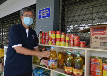 AHMAD Sabirin Arshad menunjukkan beberapa bahan makanan yang diletakkan dalam bank makanan di SIRIM Shah Alam, Selangor. - UTUSAN/MOHAMAD NAUFAL MOHAMAD IDRIS