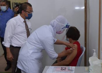 NOOR Azmi Ghazali melihat proses suntikan vaksin Covid-19 kepada seorang penerima ketika melawat Pusat Pemberian Vaksin (PPV) Dewan Merdeka, Tapah.  - UTUSAN/ZULFACHRI ZULKIFLI