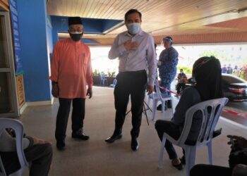 ANTHONY Loke Siew Fook (kanan) dan Bakri Sawir beramah mesra dengan seorang penerima vaksin ketika meninjau operasi pemberian vaksin di PPV Dewan D'Sury, Kuala Klawang, Jelebu. - UTUSAN/BADRUL HAFIZAN MAT ISA