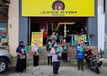 PENERIMA menunjukkan bungkusan nasi yang diterima di depan Restoran Jukee Ayam Bakar di Tambatan Di Raja, Kota Bharu. - UTUSAN/ROSALWANI CHE SOH