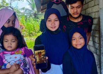 NURFARRA Asyikin Norazmi bersama empat adiknya menunjukkan gambar ibu mereka, 
Norhashimah Abdul Majid di Kampung Pasir Puteh Tualak, Kuala Nerang, Padang Terap. - UTUSAN/MOHD. RIFAAT ABD. HAMID