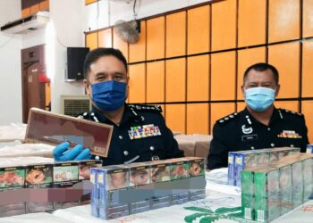 SAHABUDIN Abd. Manan (kiri) menunjukkan sebahagian daripada rokok tidak bercukai yang dirampas di IPD SPT, Bukit Mertajam, Pulau Pinang.