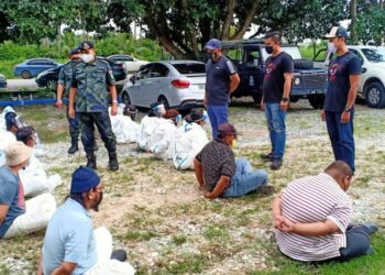 DIMIN Awang (berdiri kiri) melihat empat lelaki dan 10 PATI Indonesia yang diberkas dalam Op Benteng di jalan kebun di Parit Serong, Serkat, Pontian, Johor.