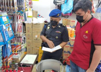 PENGUATKUASA KPDNHEP Melaka melakukan pemeriksaan di bahagian alat tulis di sebuah premis perniagaan. - UTUSAN/MUHAMMAD SHAHIZAM TAZALI