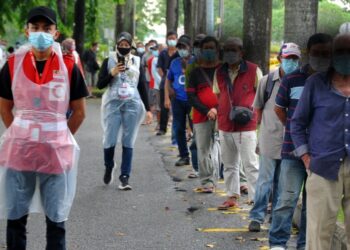 SEBAHAGIAN gelandangan beratur untuk mengambil bungkusan makanan sambil dibantu petugas Bulan Sabit Merah di Laman Tun Seri Lanang di Johor Bahru, Johor. - UTUSAN/RAJA JAAFAR ALI