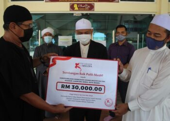 NEZALANI Nawi (kiri) menyampaikan replika cek kepada Iman Tua Masjid Sultan Mansor, Mohd. Sidek sambil disaksikan Muhammad Hana Pizi Abdullah di Kota Bharu. - UTUSAN/ROHANA MOHD. NAWI