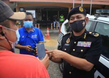 ADENAN Md. Isa menunjukkan aplikasi e-hailling yang disalahgunakan oleh pemandu apabila mengenakan tambang lebih mahal berbanding yang tertera ketika mengambil penumpang di PKRC Jawi, Pulau Pinang. - UTUSAN/MOHAMAD FIRDAUS AMRAN