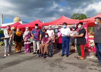 MOHD. Izhar Ahmad (tiga kanan) diiringi Che Zakaria Mohd. Salleh (empat dari kiri) menghulurkan sumbangan kepada peniaga yang terjejas akibat bencana ribut di tapak penjaja berhampiran Masjid Taman Rinting, Masai, Pasir Gudang, Johor. - UTUSAN/MOHAMAD FAIZAL HASHIM