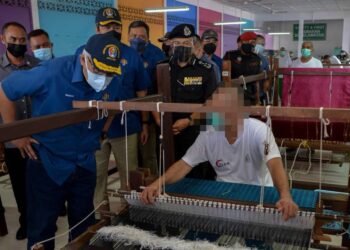 HAMZAH Zainuddin (kiri) melihat perusahaan songket yang dihasilkan banduan di Penjara Marang di Marang. - UTUSAN/PUQTRA HAIRRY ROSLI