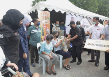 RONALD Kiandee menyampaikan kotak makanan kepada penerima dalam Program MAFI Prihatin di PPV Kompleks Sukan Pagoh, Muar di Johor. - UTUSAN/NUR ALINA HASSAN
