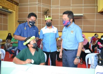 JALALUDDIN Alias beramah mesra dengan seorang masyarakat orang Asli yang menerima vaksin Covid-19 mereka di PPV Dewan D’sury, Kuala Klawang, Jelebu hari ini. UTUSAN/ZAKKINA WATI AHMAD TARMIZI.