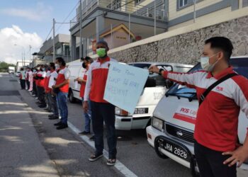 SERAMAI 23 orang pekerja Pos Rider berkumpul di hadapan Hub Pos Laju Ayer Keroh, Melaka bagi menyatakan bantahan secara aman susulan penamatan kontrak mereka. - UTUSAN/DIYANATUL ATIQAH ZAKARYA