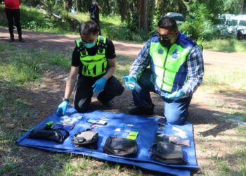 NORZAMRI Abd. Rahman (kanan) menunjukkan rampasan dadah dalam Op Sarang Khas di 'port' dadah dalam ladang Felda Jengka 16 di Maran, Pahang. - UTUSAN/SALEHUDIN MAT RASAD