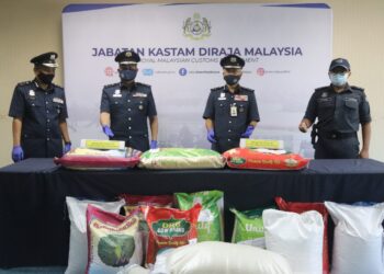 ZAZULI Johan (dua dari kanan) menunjukkan sebahagian beras yang dirampas pihaknya di Pelabuhan Barat, Klang. - GAMBAR IHSAN JKDM