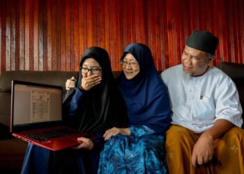 NAJWA Mohd. Kamal, 20, memeriksa keputusan Sijil Tinggi Persekolahan Malaysia (STPM) 2020 bersama ibu bapanya di Kampung Beladau Kolam di Kuala Terengganu. - UTUSAN/PUQTRA HAIRRY ROSLI