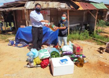 MAS Imran Adam (kiri) menyerahkan sumbangan barang makanan kepada buruh binaan warga asing yang tinggal di rumah kongsi di Sungai Rengit selepas terputus bekalan makanan sejak sebulan lalu di Kota Tinggi, Johor.