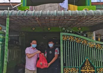 JIMMY Puah Wee Tse (kiri) menyampaikan sumbangan barangan keperluan harian kepada kediaman yang dikesan menaikkan bendera putih di Taman Putri, Kulai di Johor.