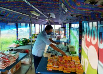 ZAMBRI Mat menyusun barangan makanan yang disediakan di dalam bas yang diubah suai menjadi bank makanan di Taman Budiman, Alor Setar. - UTUSAN/MOHD. RAFIE AZIMI