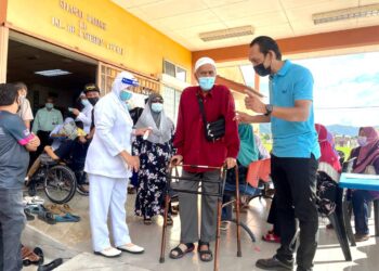 NOR Azam Karap (kanan) memimpin Johar Char selepas selesai menerima suntikan vaksin pada program vaksinasi warga emas, pesakit berisiko, dan OKU di Klinik Desa Seberang Ramai, Kuala Perlis. - UTUSAN/NAZLINA NADZARI