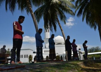 BEBERAPA jemaah menunaikan solat Jumaat di pekarangan Masjid Tengku Tengah Zaharah atau dikenali sebagai Masjid Terapung di Kuala Terengganu. - UTUSAN/PUQTRA HAIRRY ROSLI