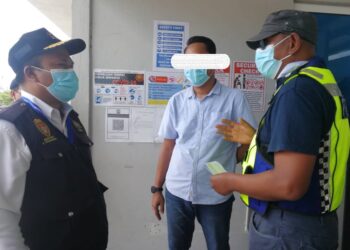 HANYAN Ramlan (kanan) memberi peringatan kepada wakil pekerja kilang pembuatan sarung tangan ketika Op Patuh di kawasan perindustrian Kertih di Kemaman. - UTUSAN/NIK NUR IZZATUL HAZWANI NIK ADNAN