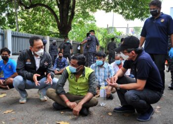 AWANG Hashim (dua dari kiri) menyoal pekerja asing yang diperiksa ketika Operasi Pematuhan Akta 446 dan SOP PPN di sebuah kilang di kawasan perindustrian Taman Gembira di Johor Bahru, Johor. - UTUSAN/RAJA JAAFAR ALI