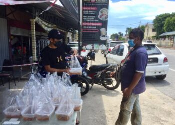 MOHD. Harrif Saleh mengagihkan 160 pek gulai ayam kampung kepada orang ramai di Kampung Panji Alam di Kuala Terengganu. - UTUSAN/TENGKU DANISH BAHRI TENGKU YUSOFF