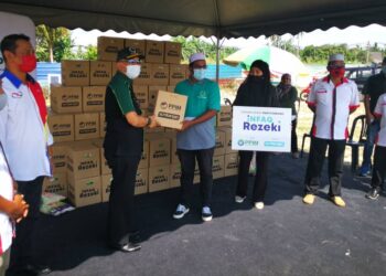 NADZIM Johan (kiri) menyampaikan sumbangan Infaq Rezeki yang berupa kotak mengandungi bekalan makanan kepada wakil penerima di Kampung Perepat, Kapar. - UTUSAN/ABDUL RAZAK IDRIS