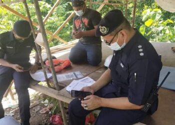 POLIS membuat pemeriksaan seorang pekerja di sebuah tapak pembinaan berdekatan Lebuhraya Central Spine Road (CSR) sempena Op Patuh di Lipis, Pahang. - IHSAN IPD LIPIS