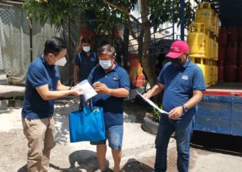 OH Tong Keong (kiri) menyerahkan bantuan kepada penduduk yang terkesan akibat pandemik Covid-19  di sekitar Bayan Baru, Pulau Pinang.