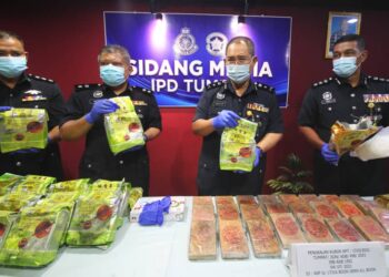 ABDULLAH (dua dari kanan) bersama pegawainya menunjukkan dadah yang dirampas pada sidang akhbar di IPD Tumpat hari ini. - UTUSAN/ZULHANIFA SIDEK