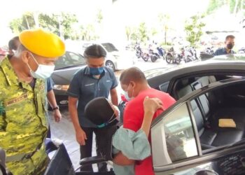 MUHAMMAD Abdullah (berbaju merah) mengangkat ibunya, Halimah Saad ketika tiba di PPV Dewan Milenium, Kepala Batas, Pulau Pinang untuk menerima vaksin menaiki kenderaan percuma yang disediakan Lembaga Kemajuan Wilayah Pulau Pinang (Perda).