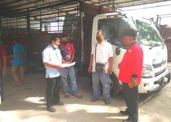ABDUL Razak Khasbullah (kanan) mendengar keluhan pemandu lori Peladang yang tidak boleh melepasi Sekatan Jalan Raya (SJR) disebabkan tiada surat MITI di Pusat Pengumpulan Hasil Ladang Teluk Panglima Garang, Kuala Langat, Selangor. - UTUSAN/ ABDUL RAZAK IDRIS